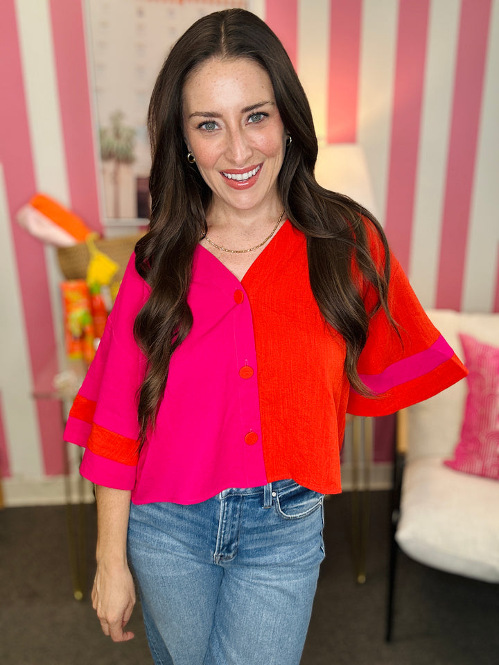 Woman wearing a colorful blouse with a striped wall in the background