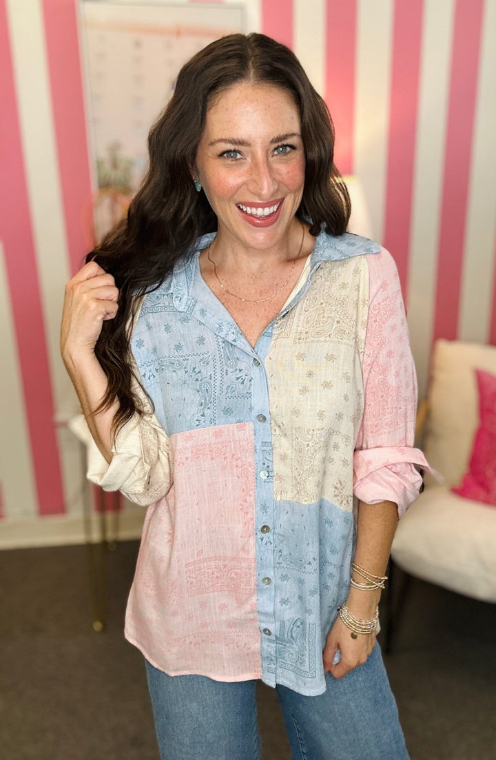 Woman wearing a colorful patchwork shirt with a striped background