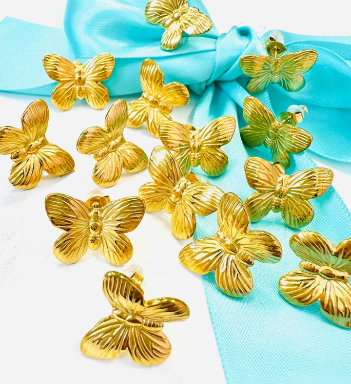 Gold butterfly-shaped objects on a turquoise fabric background