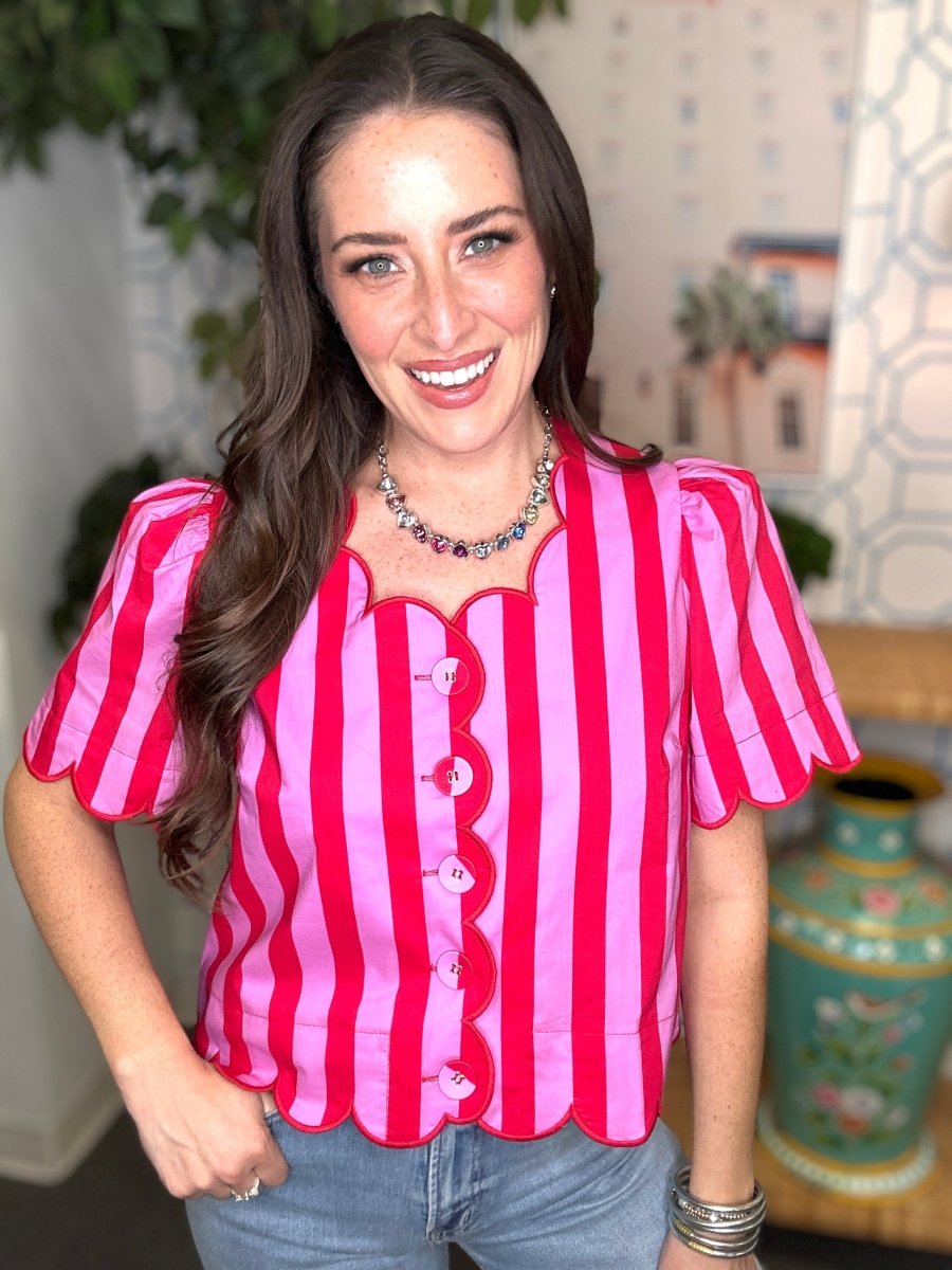 Woman wearing a red and pink striped shirt with a blurred indoor background