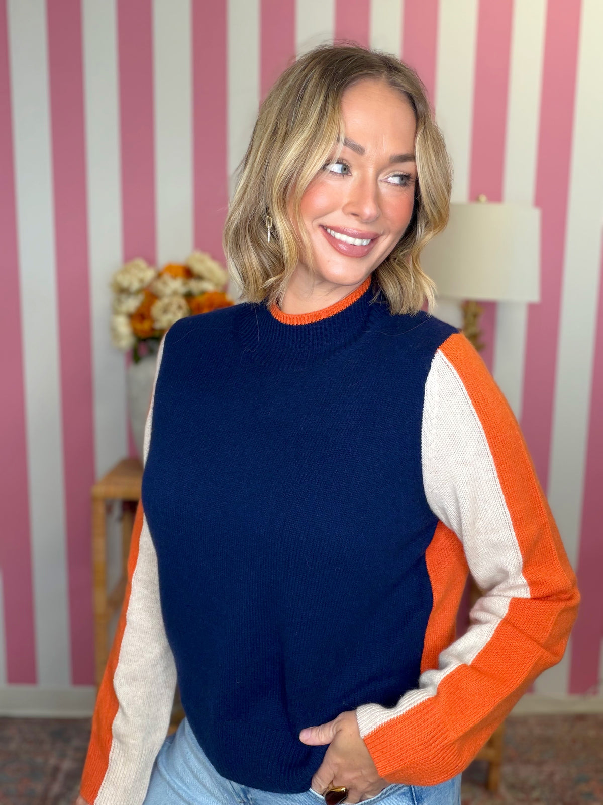 woman standing in a blue top with orange stripes