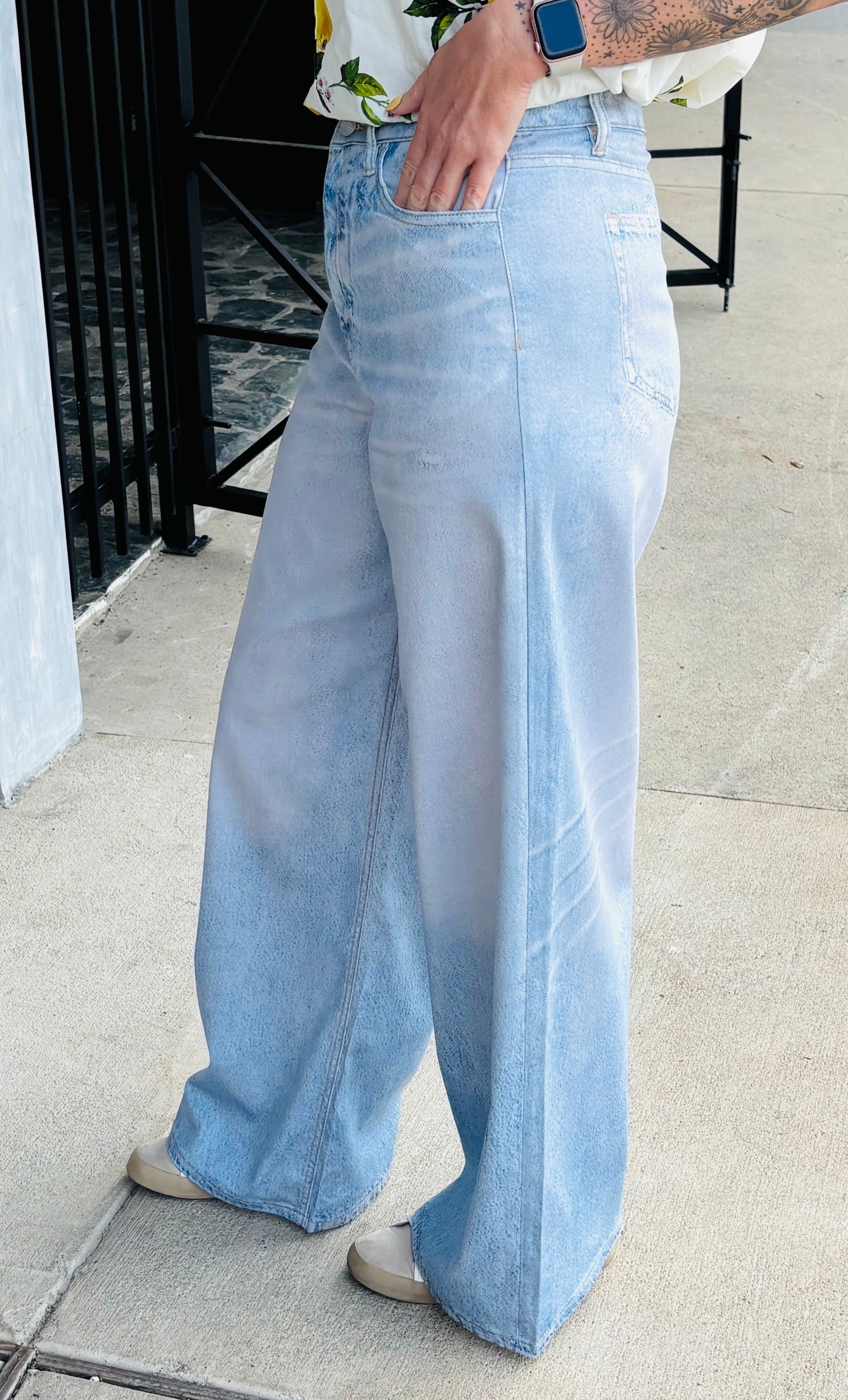 Light blue jeans worn by a person on a sidewalk.