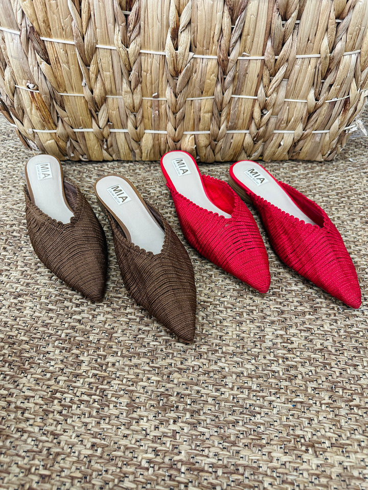 Brown and red pointed-toe shoes with 'MIA' branding on a textured surface.