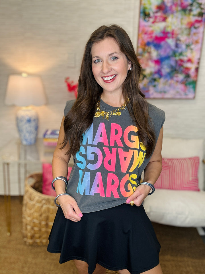Woman wearing a colorful 'MARGS' shirt in a living room setting