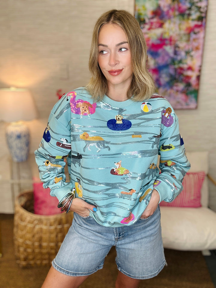Woman wearing a colorful patterned sweater in a living room setting