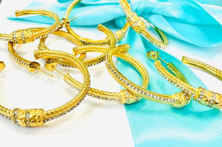 Gold bangles on a light blue fabric background