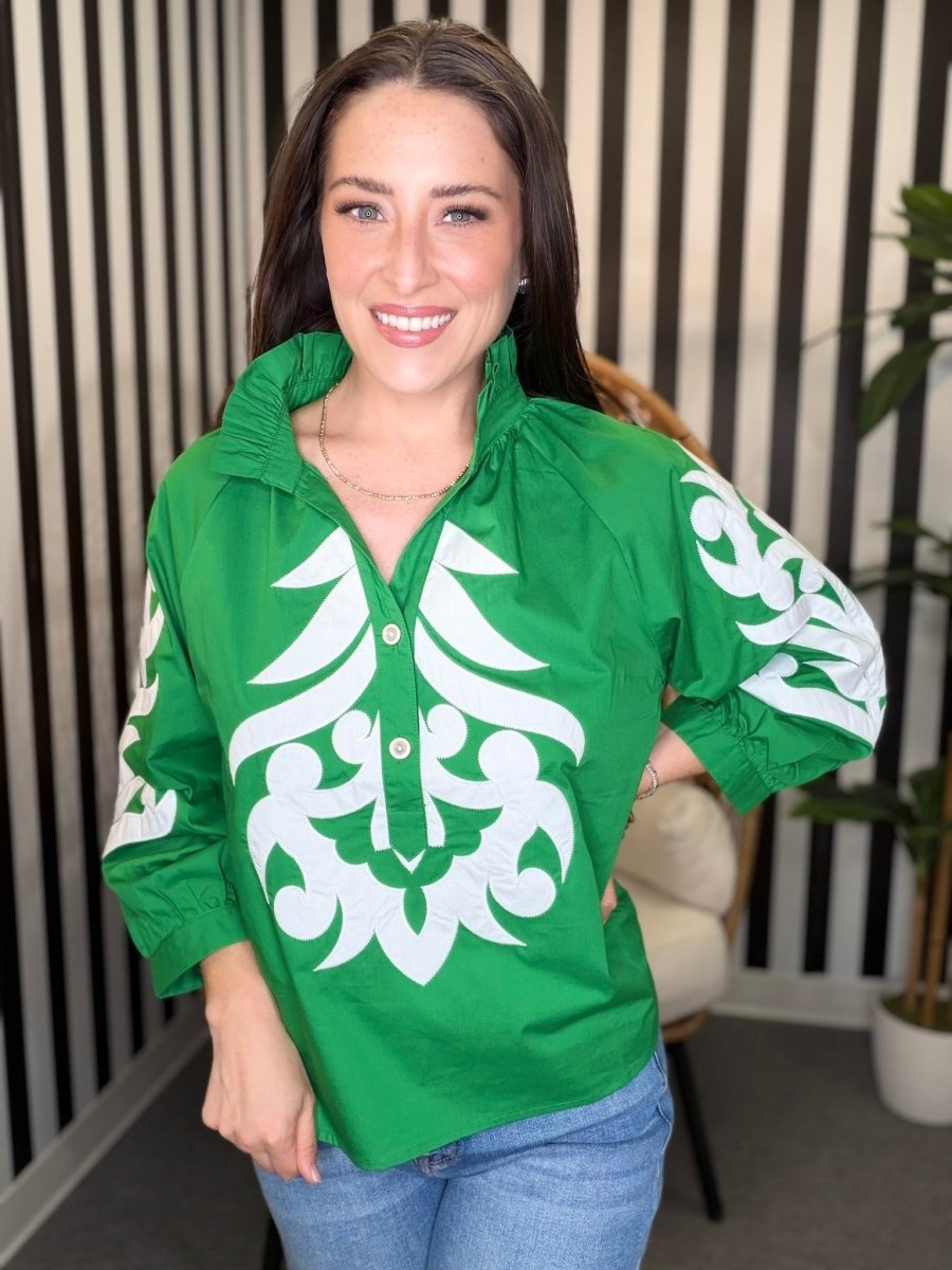 Woman wearing a green jacket with white patterns indoors