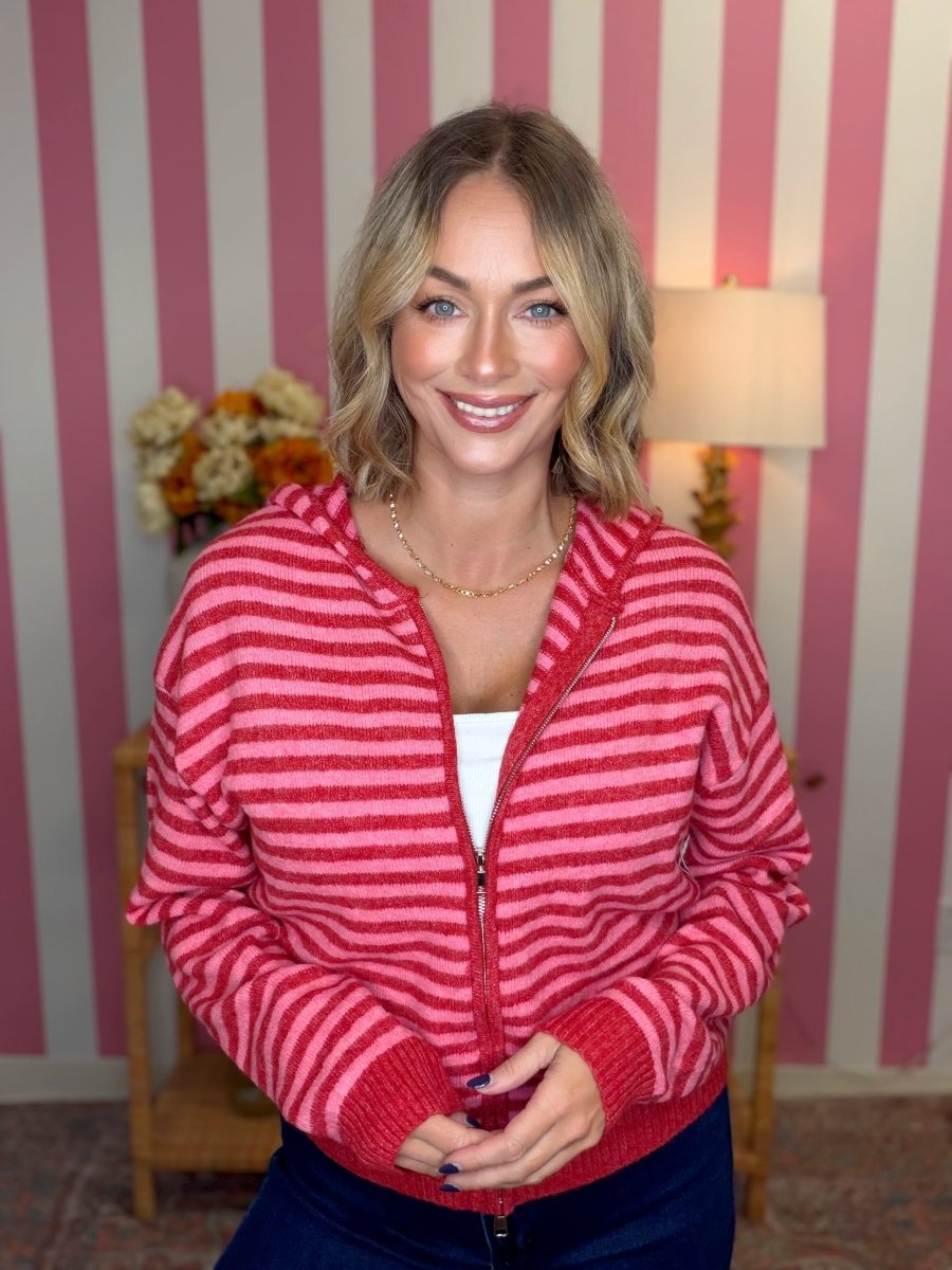 woman standing in a pink and red striped hoodie
