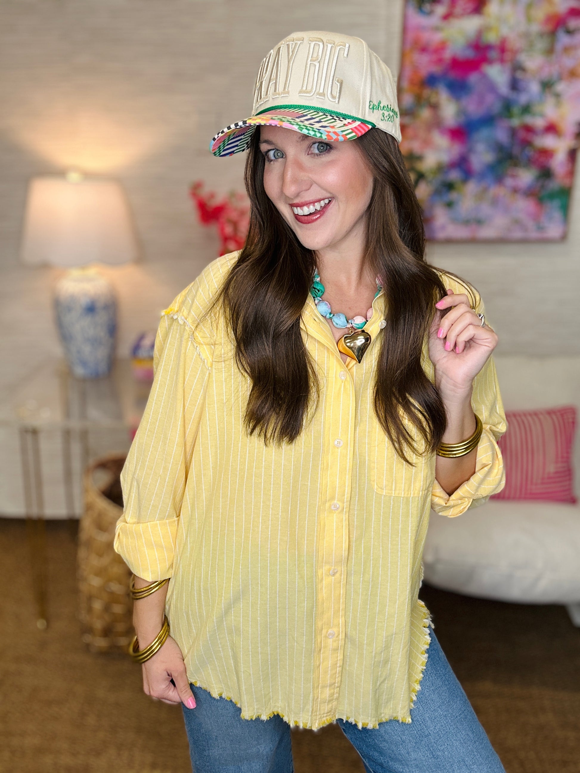 Woman wearing a yellow blouse with colorful jewelry in a living room setting