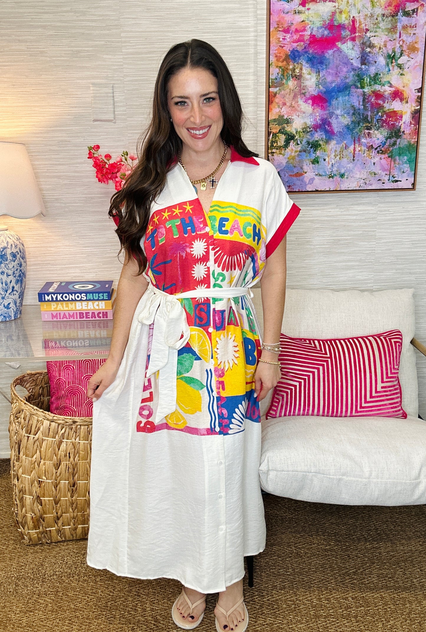 Woman wearing a colorful beach-themed dress in a living room setting