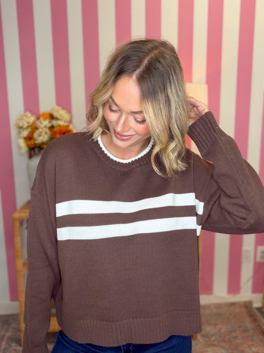 woman standing wearing a brown and white striped sweater