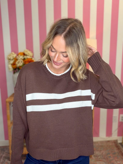woman standing wearing a brown and white striped sweater