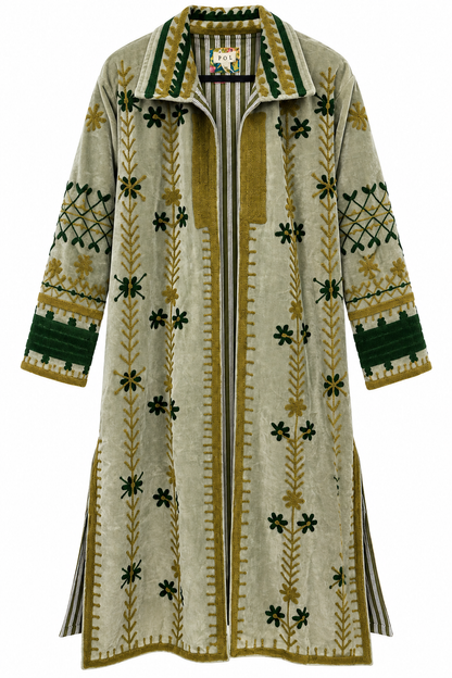 A long open-front cardigan with a cream base and intricate green and olive-yellow embroidered patterns, including floral motifs, vertical stripes, and geometric designs on the sleeves.