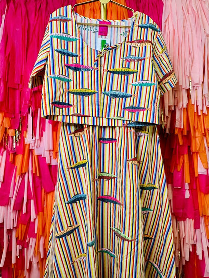 Colorful striped outfit on a hanger against a vibrant background