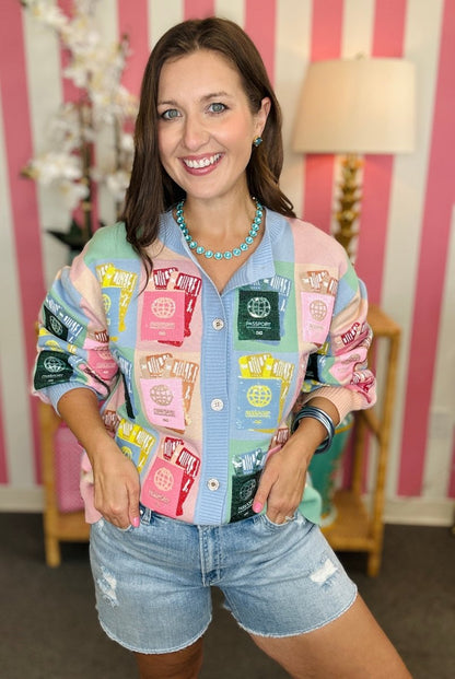 Woman wearing a colorful patchwork jacket in a room with striped wallpaper.