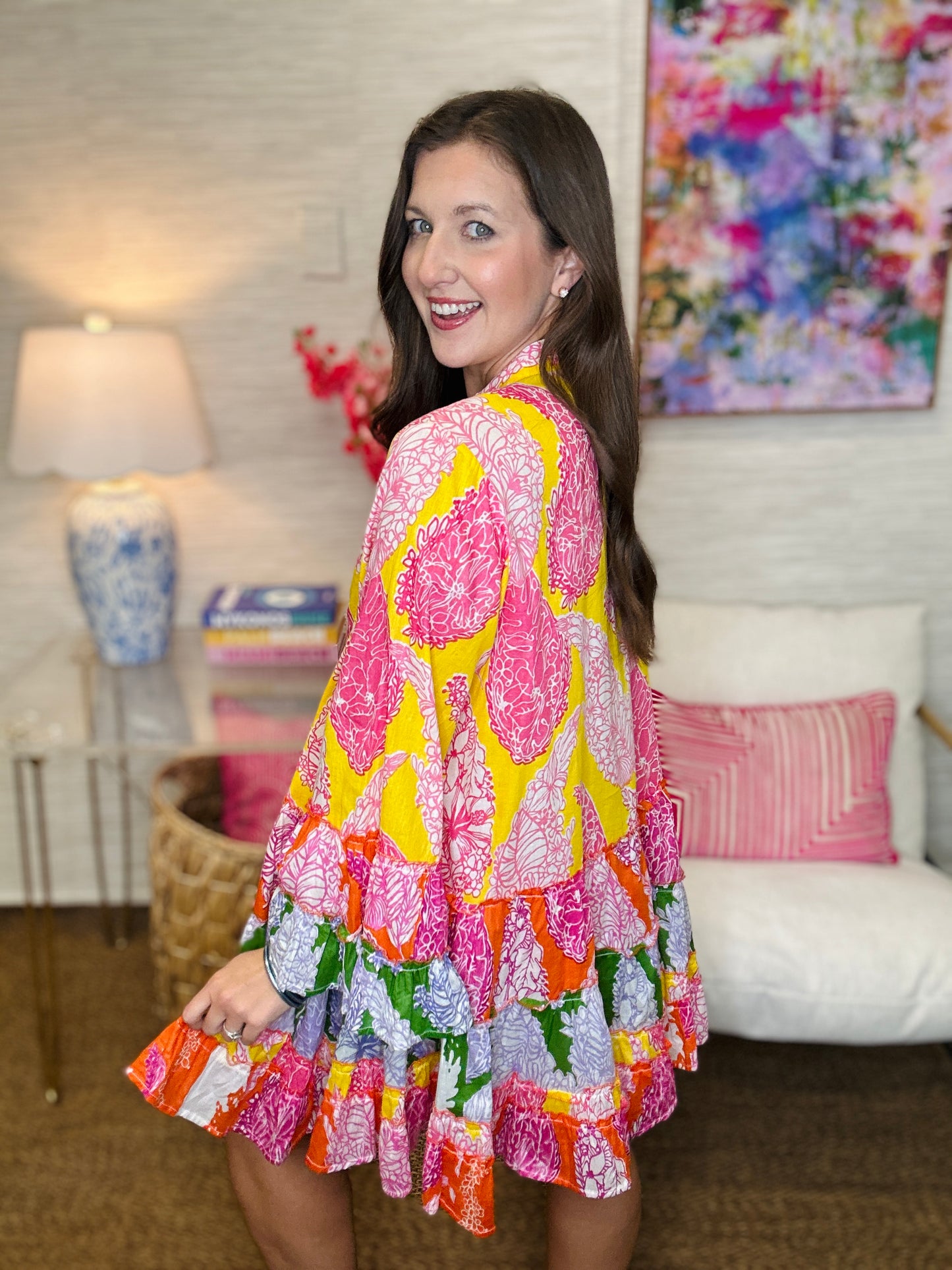 Woman wearing a colorful patterned dress in a living room setting