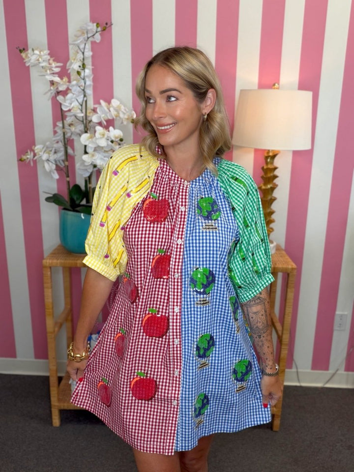 woman standing in a living room with a teacher themed dress