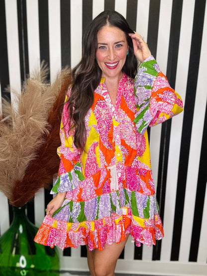 woman standing in a colorful printed dress.