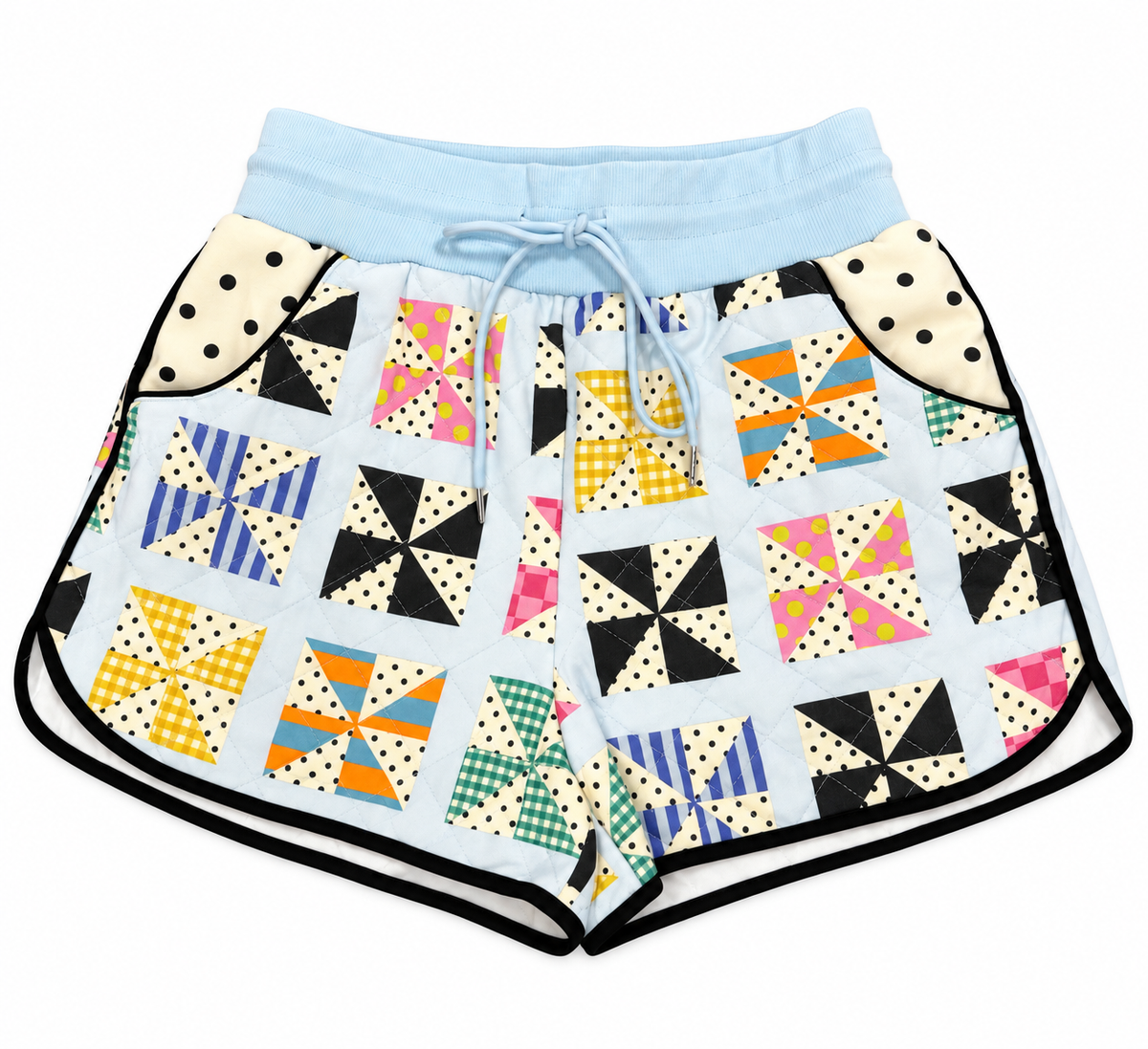A pair of women's athletic shorts featuring a colorful geometric pinwheel quilt pattern on a light blue base, with a solid light blue waistband, white drawstring, and black trim along the edges.