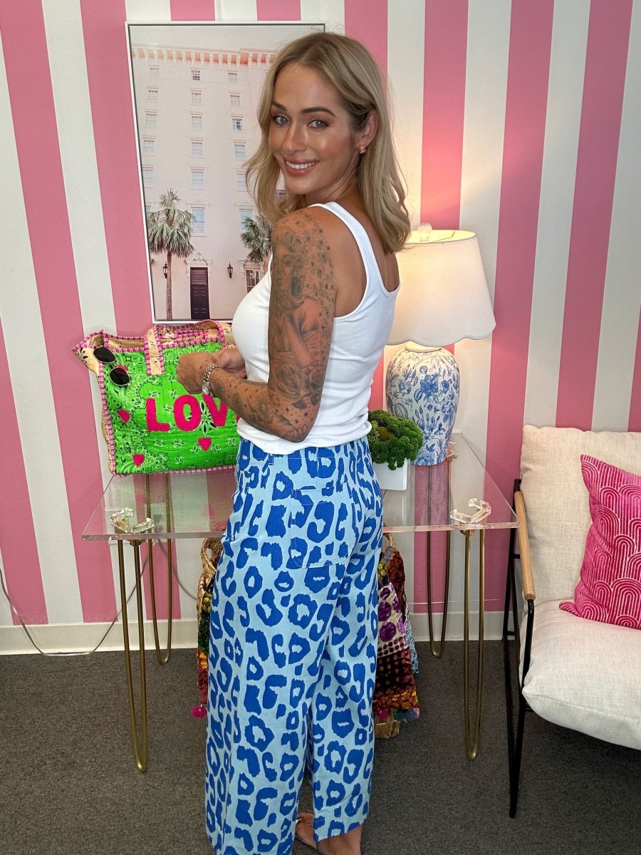 woman standing in blue pants in front of a striped wall