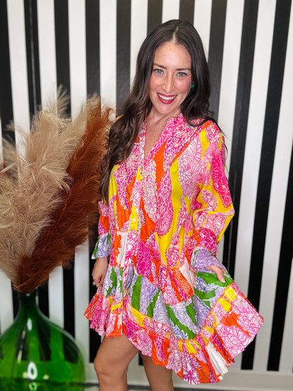 woman standing in a colorful printed dress.