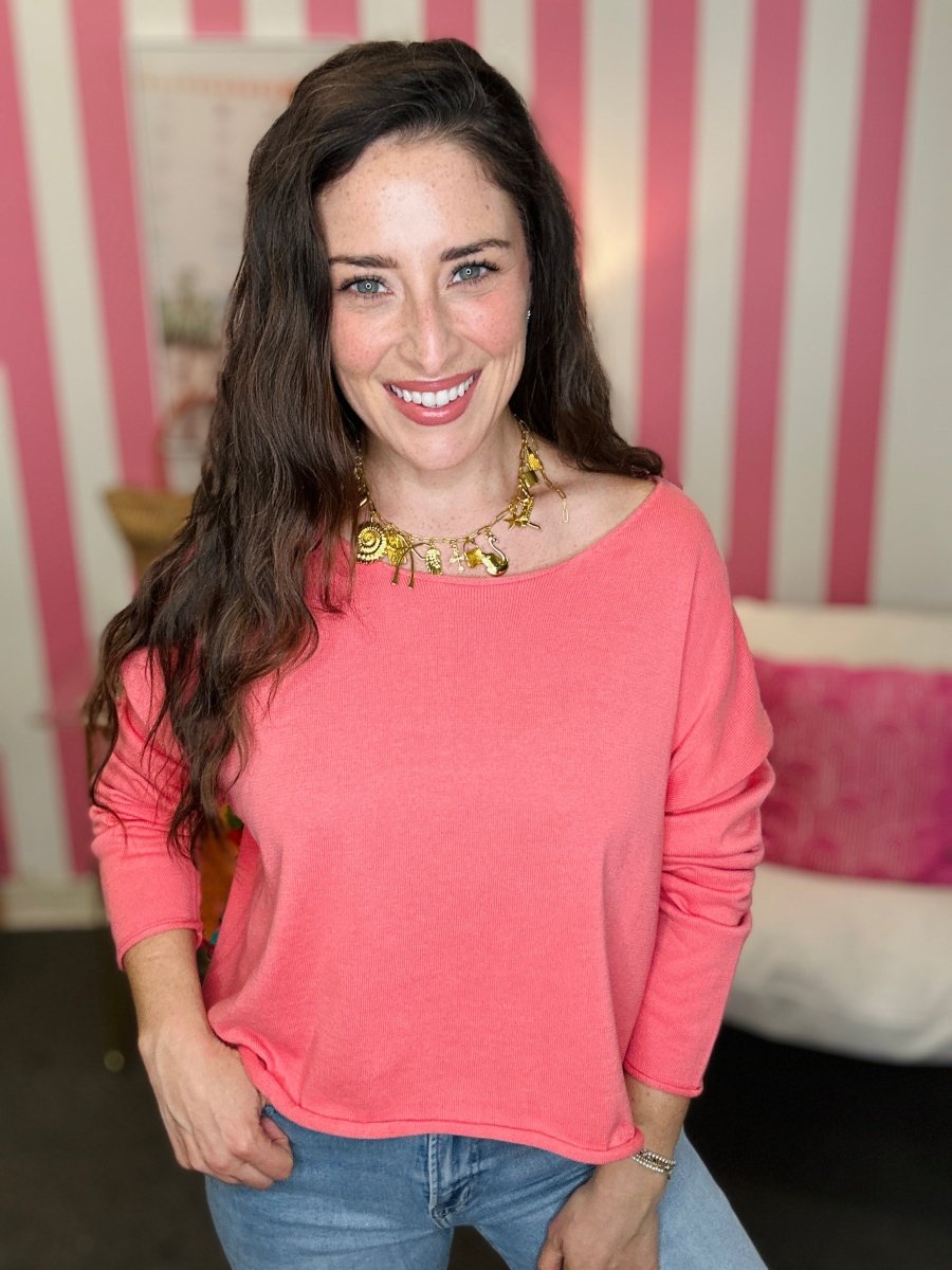 Woman wearing a pink top and blue jeans with a striped background