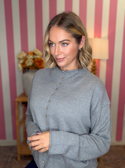 woman standing in a grey sweater