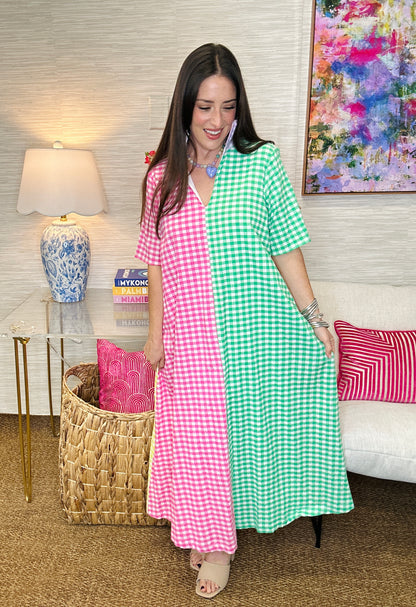 Woman wearing a pink and green checkered dress in a living room setting.