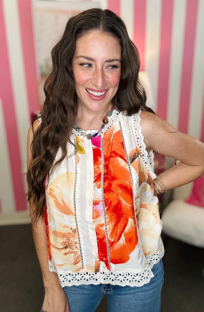 Woman wearing a colorful floral top with a blurred background