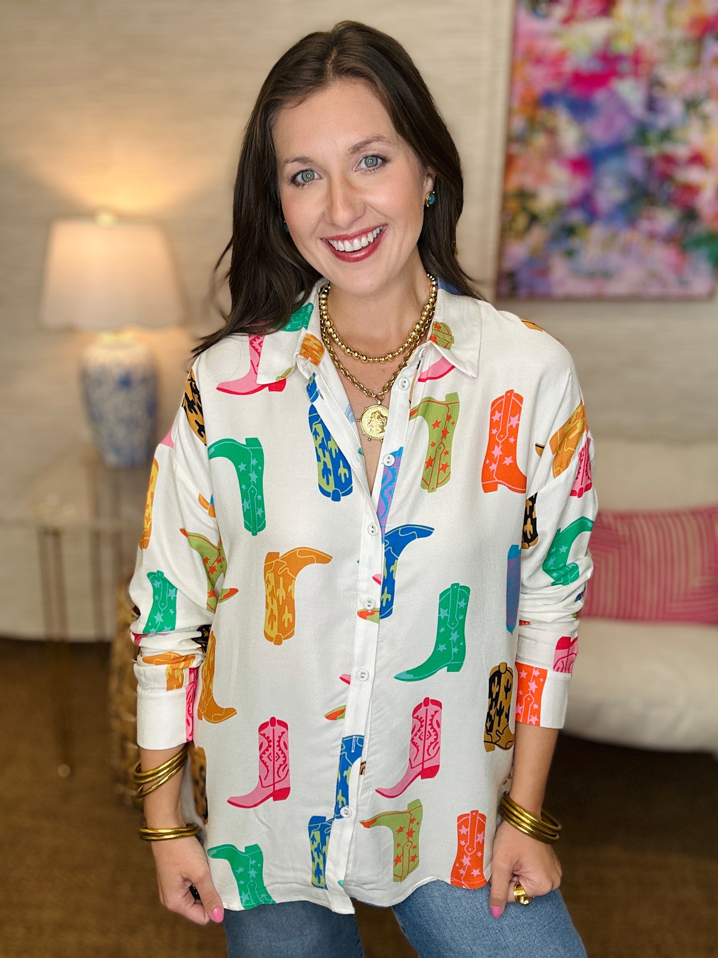 Woman wearing a colorful boot patterned shirt in a living room setting