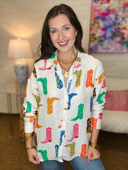 Woman wearing a colorful boot patterned shirt in a living room setting