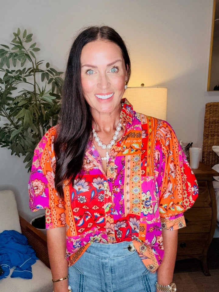 Woman wearing a colorful patterned blouse in a home setting