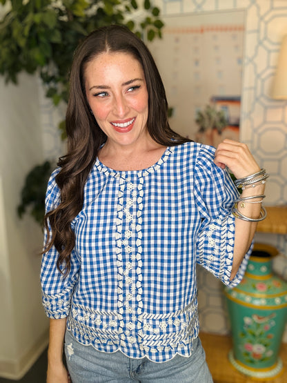 Woman wearing a blue and white checkered blouse in a home setting