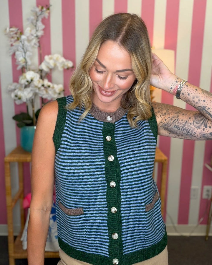 woman standing in a living room in a blue and green striped sweater
