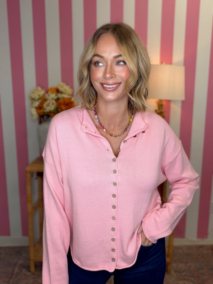 woman standing in a pink sweater