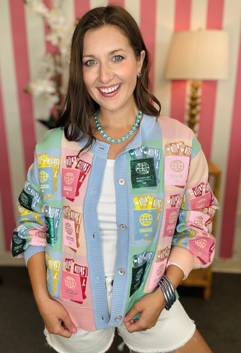 Woman wearing a colorful patterned jacket in a room with striped wallpaper.