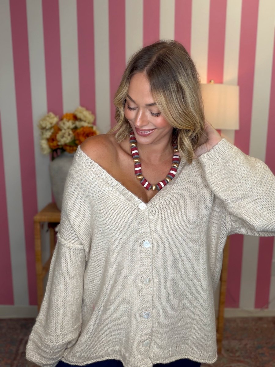 woman standing in a room in a beige sweater