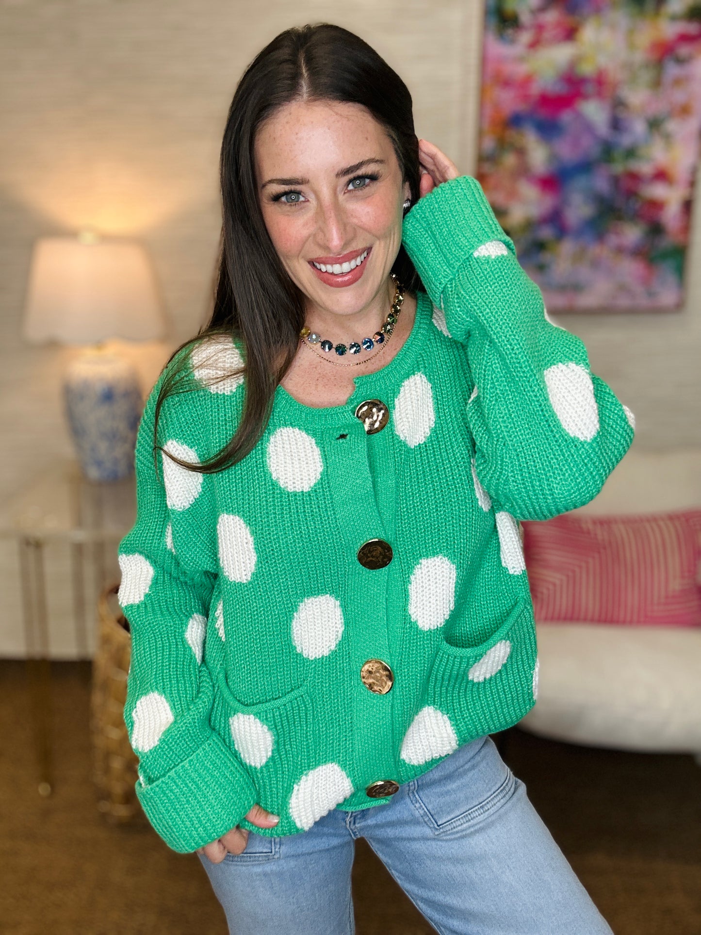 Woman wearing a green sweater with white polka dots indoors