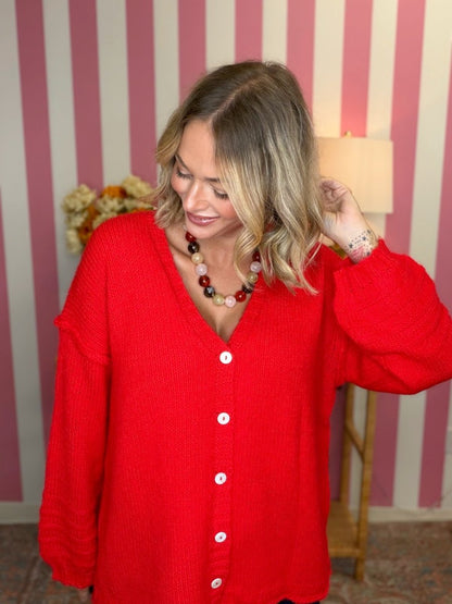 woman standing in a room in a red sweater