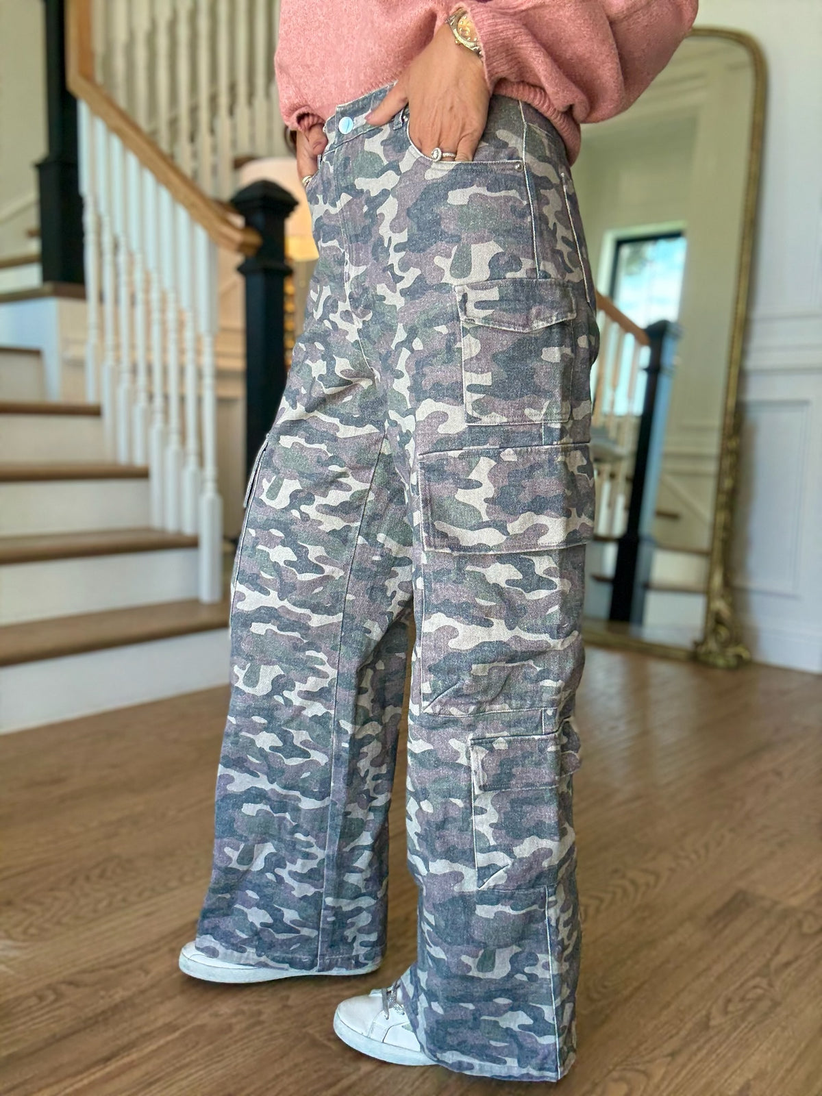 woman standing in a pink sweater and camo cargo pants