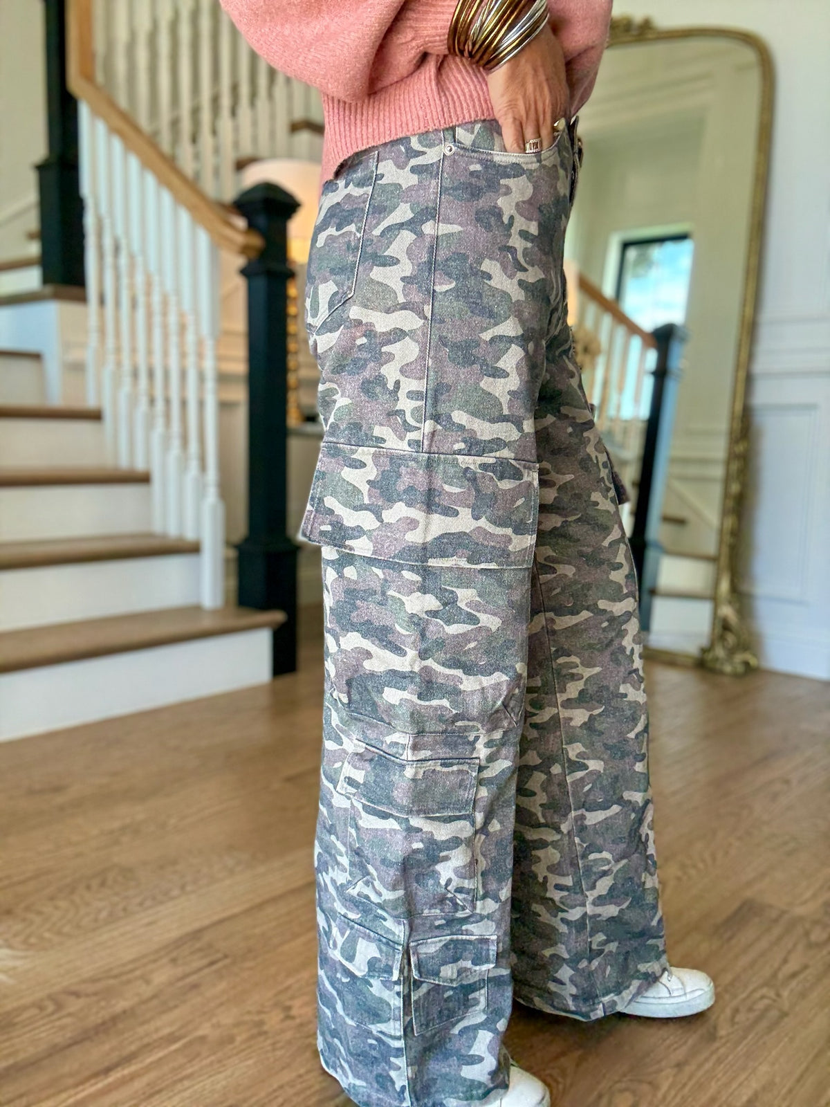 woman standing in a pink sweater and camo cargo pants