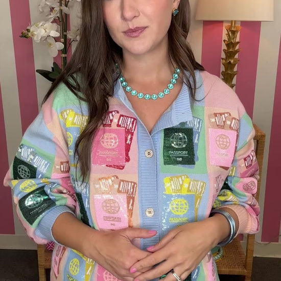 Woman wearing a colorful patchwork jacket with a striped wall background
