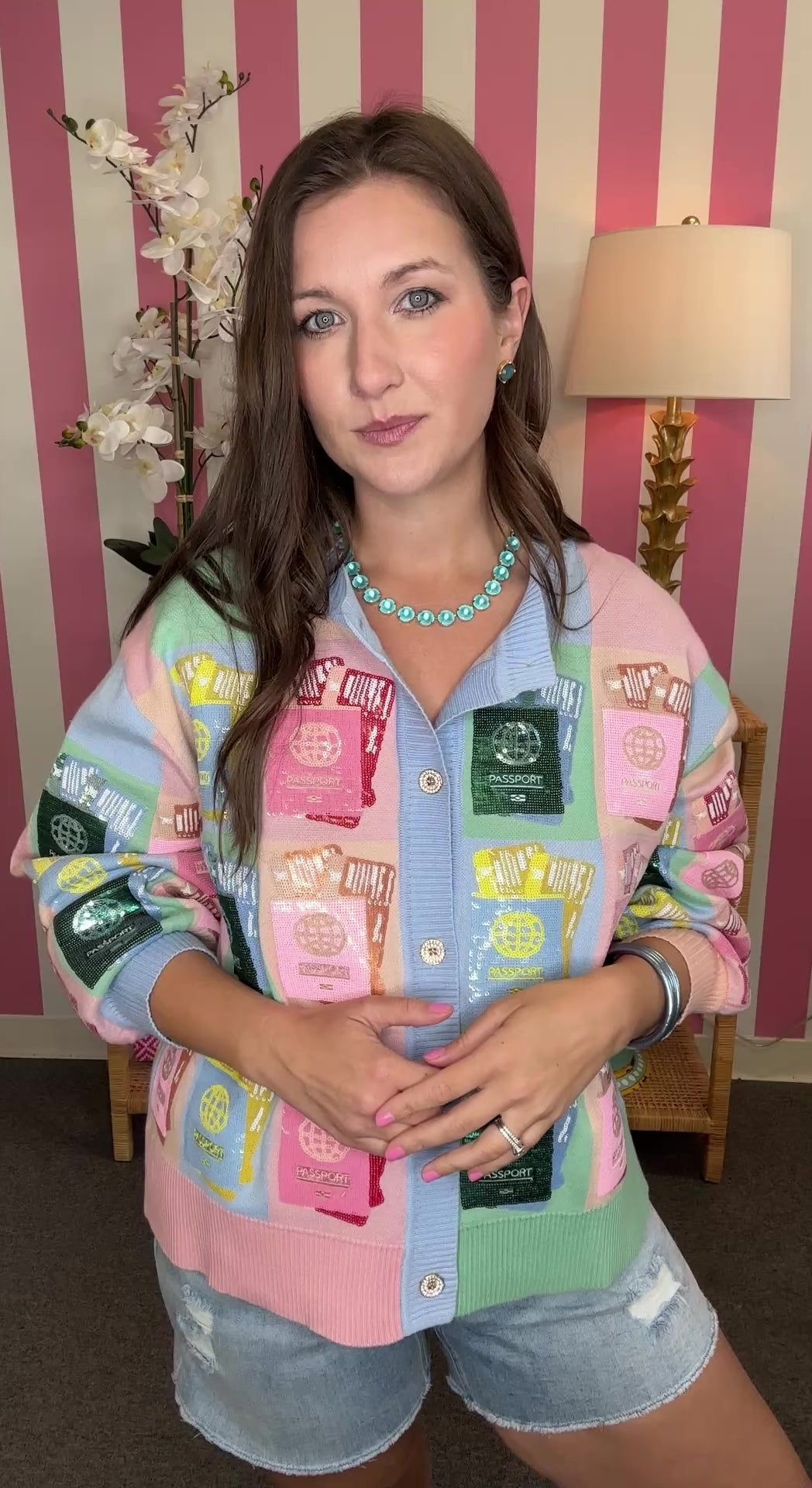 Woman wearing a colorful patchwork jacket with a striped wall background