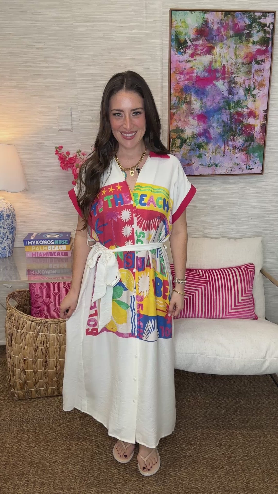 Woman wearing a colorful beach-themed dress in a living room setting