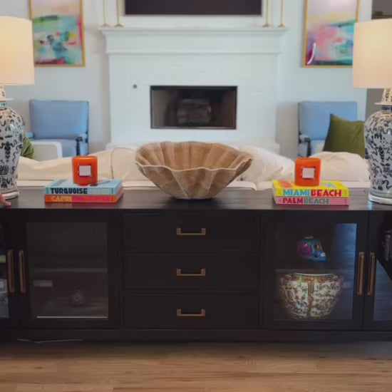 two women in colorful towel wraps moving around the living room.