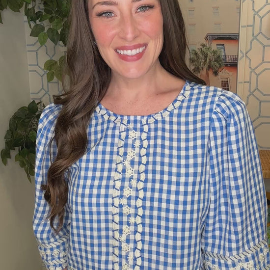 Woman wearing a blue and white checkered blouse in a home setting