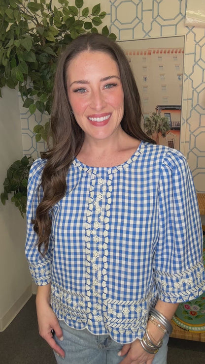 Woman wearing a blue and white checkered blouse in a home setting