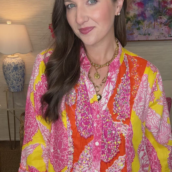 Woman wearing a colorful patterned dress in a living room setting