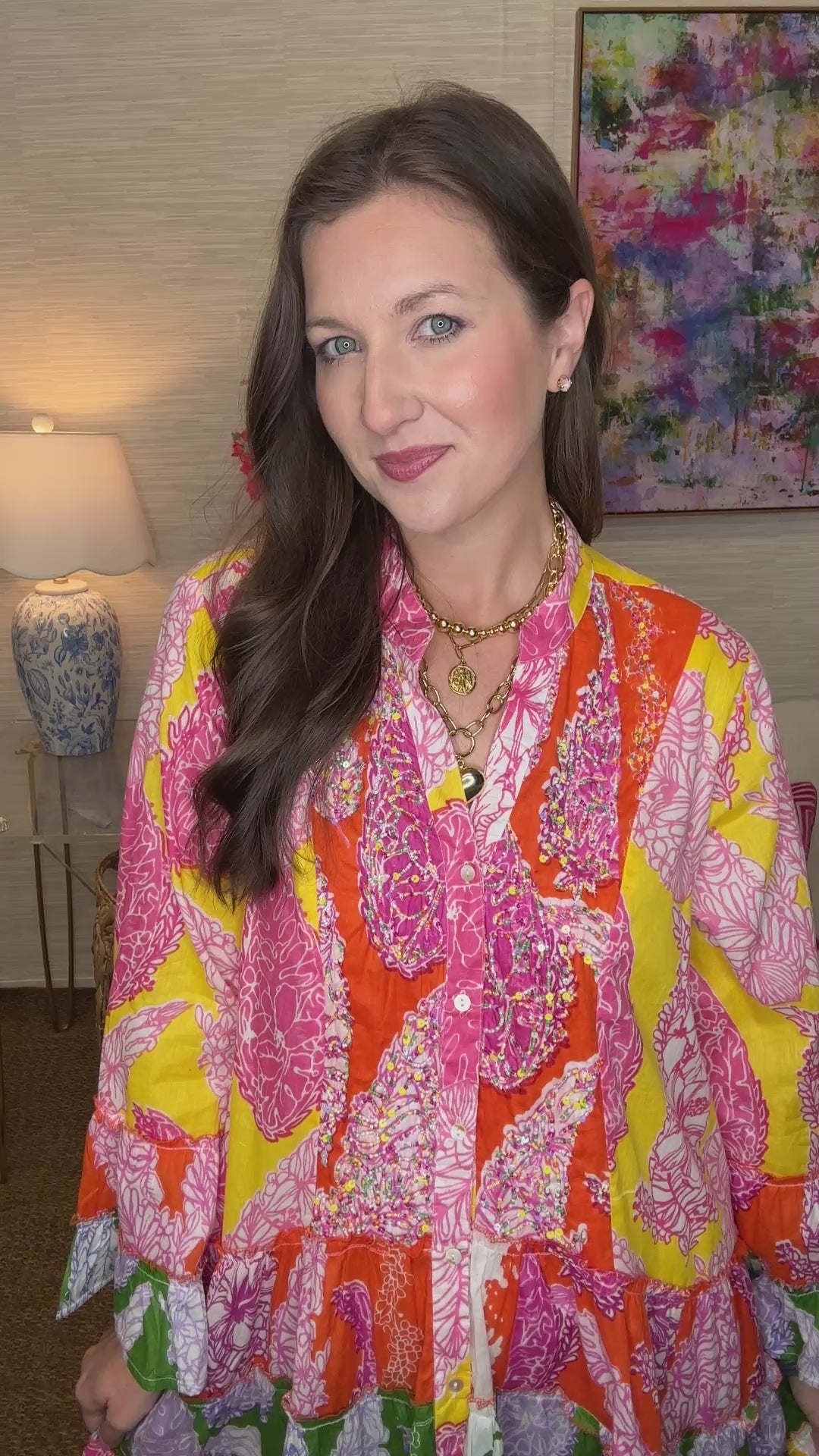 Woman wearing a colorful patterned dress in a living room setting