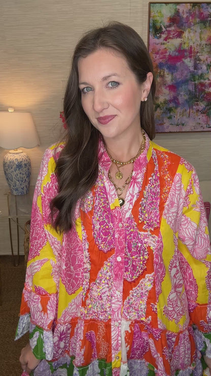 Woman wearing a colorful patterned dress in a living room setting